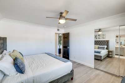 Relax in the inviting ambiance of this spacious bedroom, featuring sleek decor and natural light.