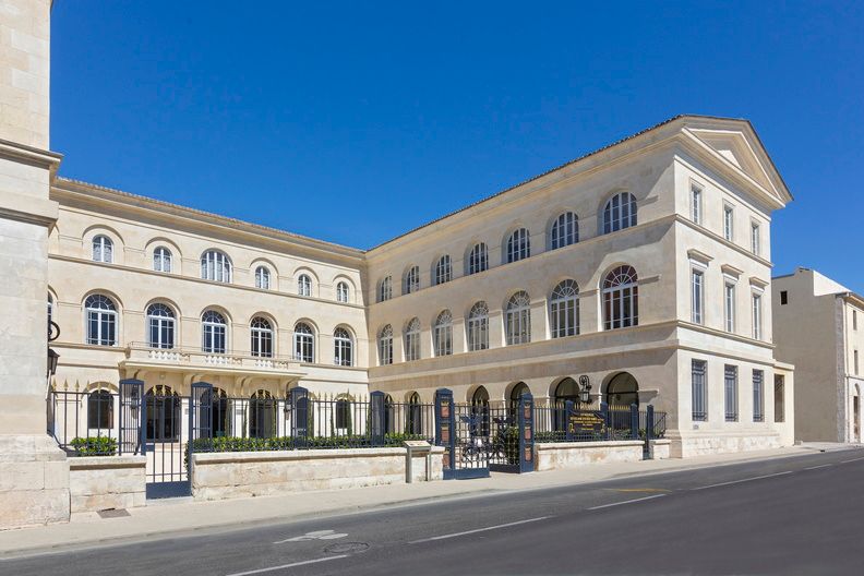 image The historic stone facade of Le Grand Hôtel Dieu, a listed monument in the heart of Nîmes, steps from the Roman amphitheatre.
