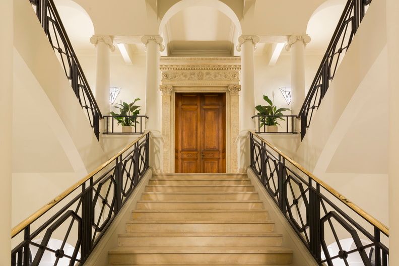 image The monumental staircase, one of the hotel's signature architectural elements, adorned with original mouldings and an ornate ironwork railing.