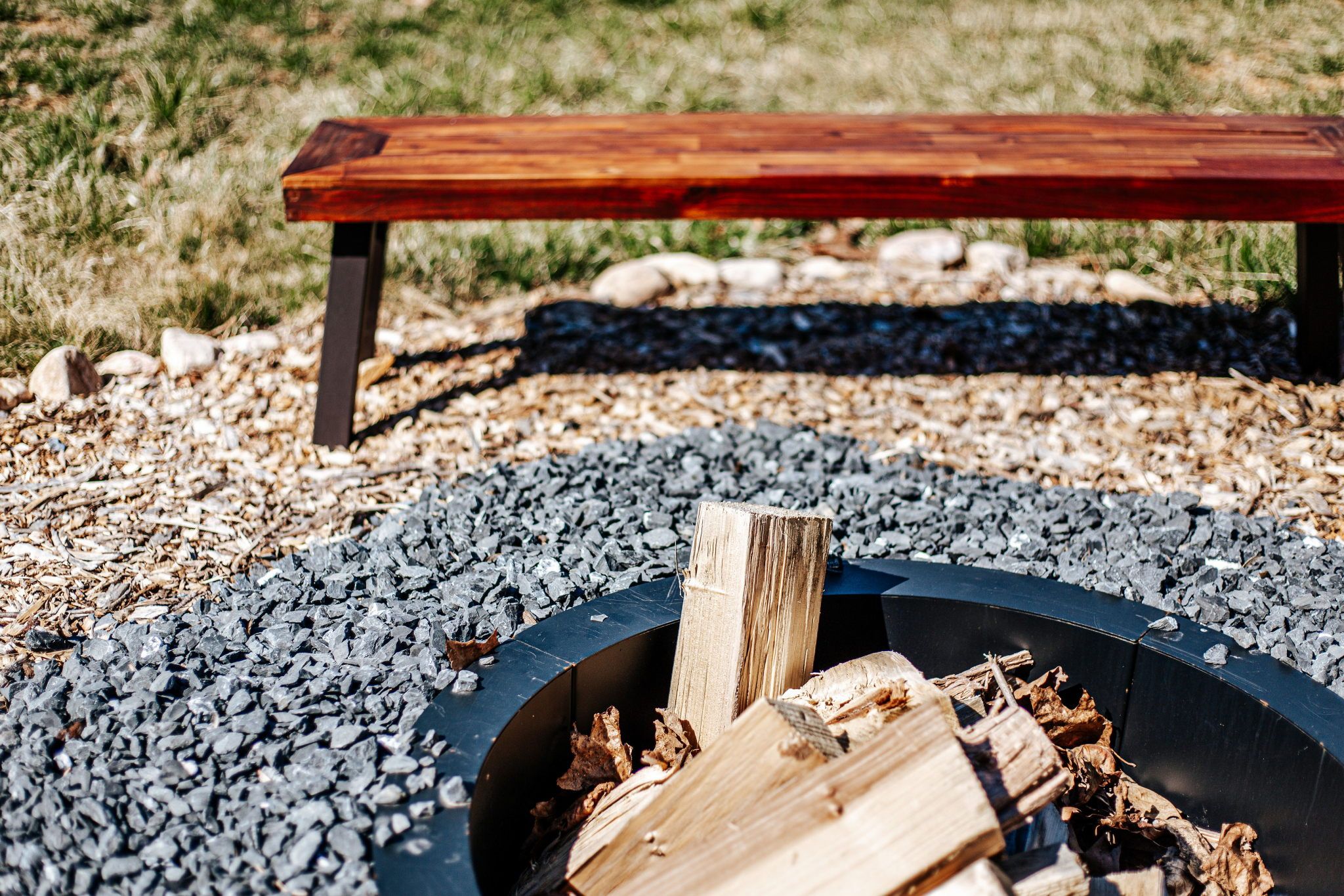 image Enjoy warm evenings by the fire pit with rustic wooden seating, inviting relaxation and connection.