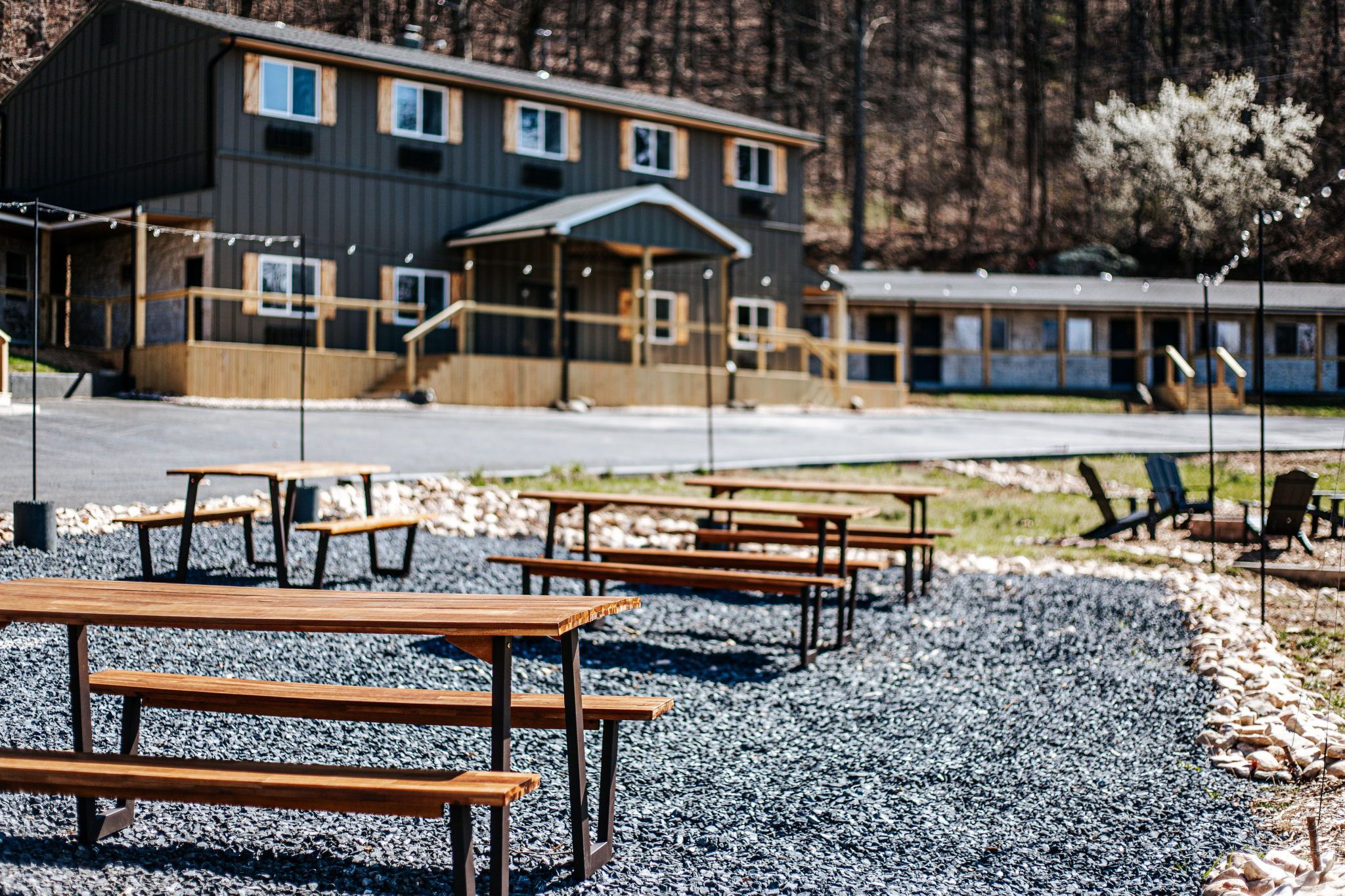 image Enjoy outdoor dining with sleek wooden tables set amidst natural stone paths.
