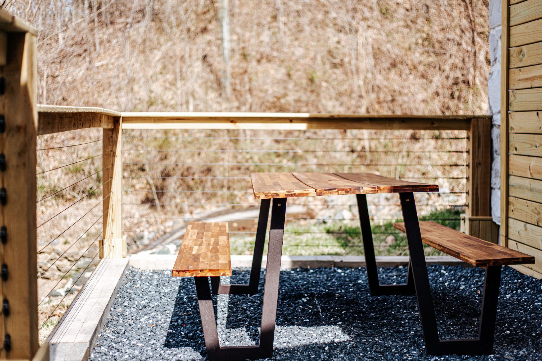 image Gather around the rustic wooden picnic table surrounded by serene nature.
