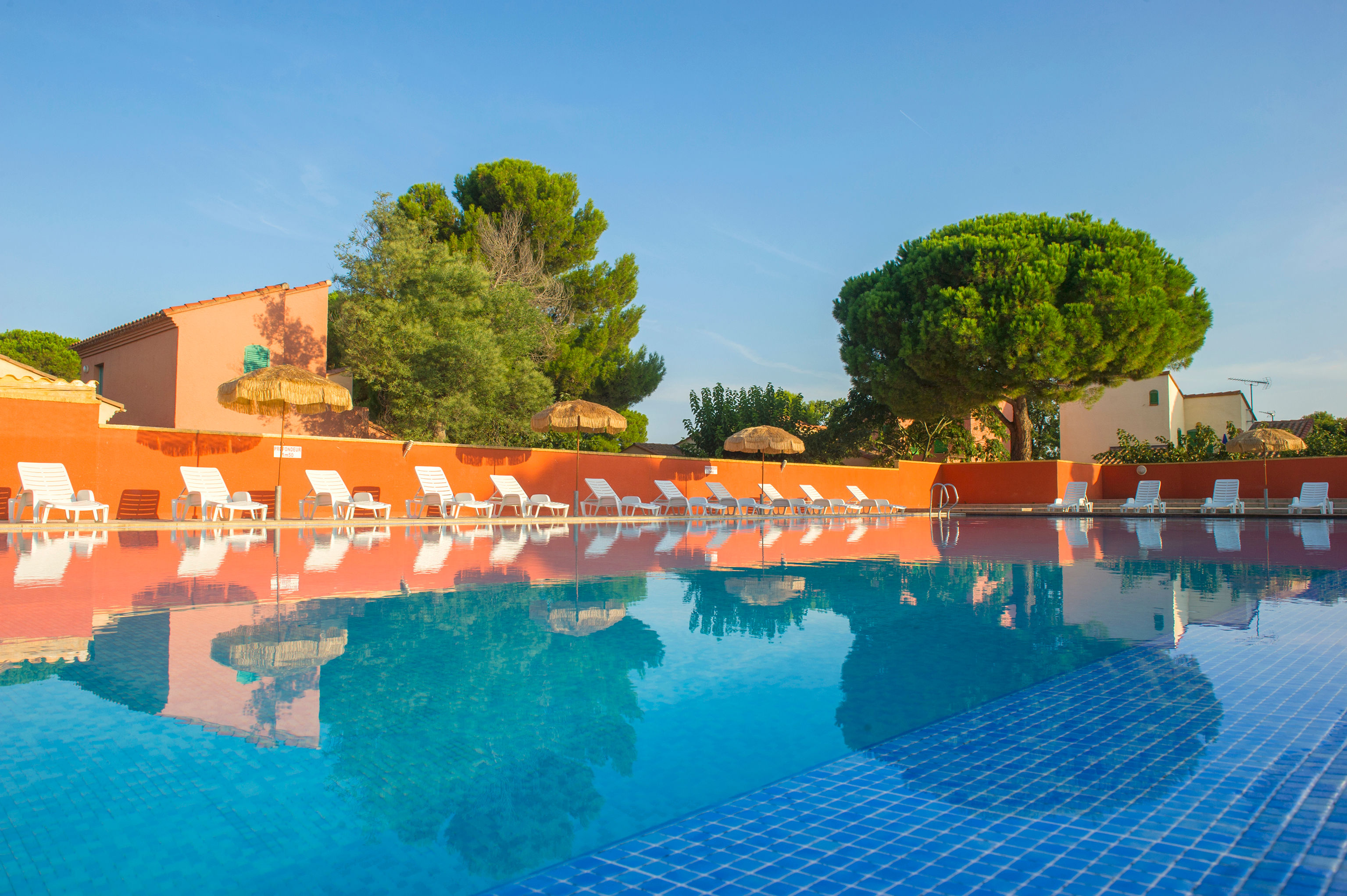 image Clear blue water reflects the terracotta rooflines — the pool is the social heart of the 10-hectare domain.