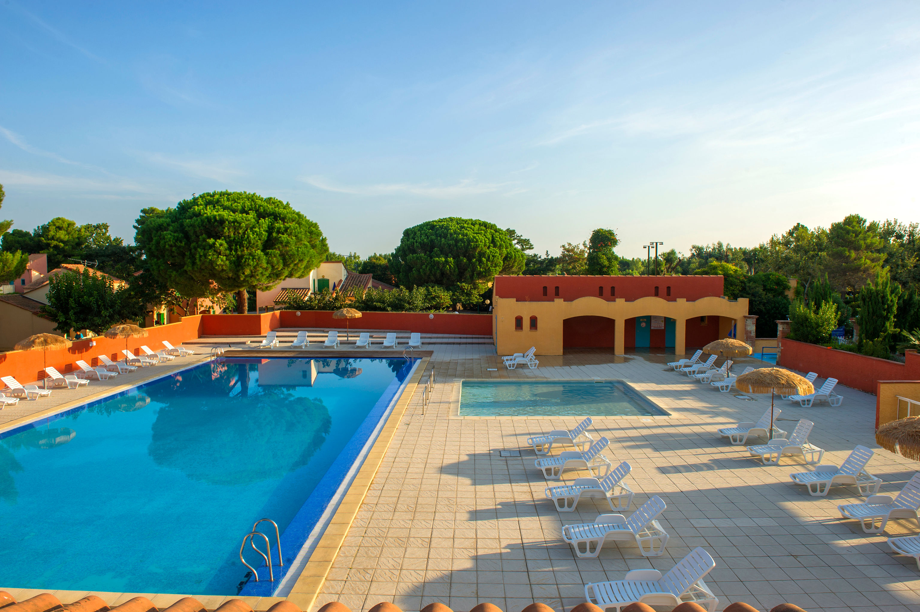 image The outdoor pool open from May to September, ringed by sun loungers and framed by ochre walls and pines.