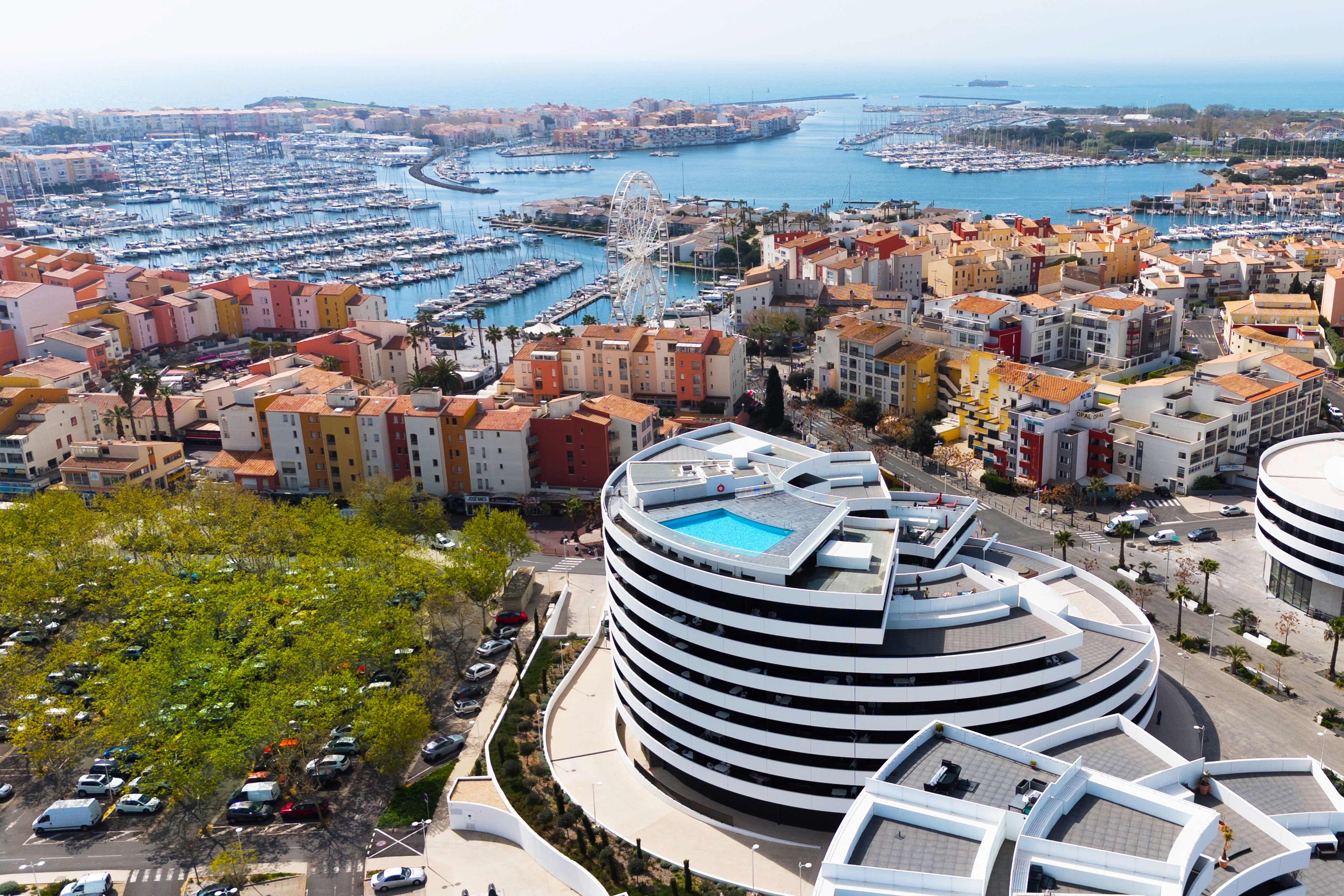 image Cap d'Agde's marina from above — boats, a Ferris wheel, and the Languedoc coastline right on your doorstep.