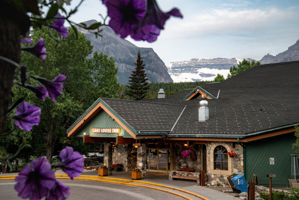 image The inviting entrance awaits, framed by vibrant flowers and the majestic Rockies.