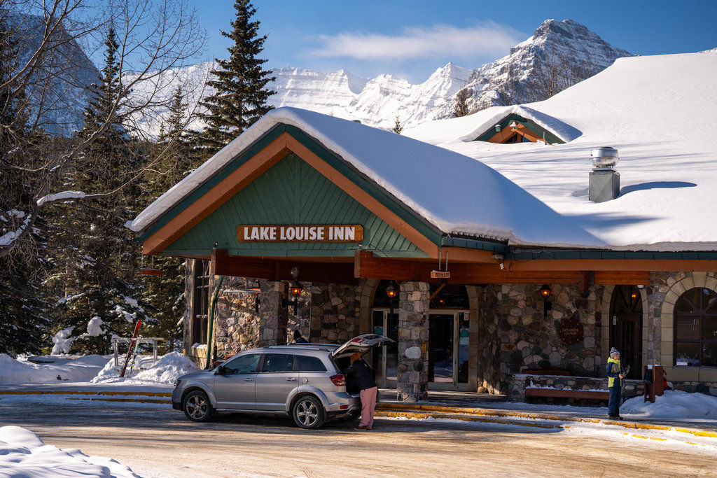 image Arrive at a cozy entrance, framed by snow-dusted evergreens and majestic mountain views.