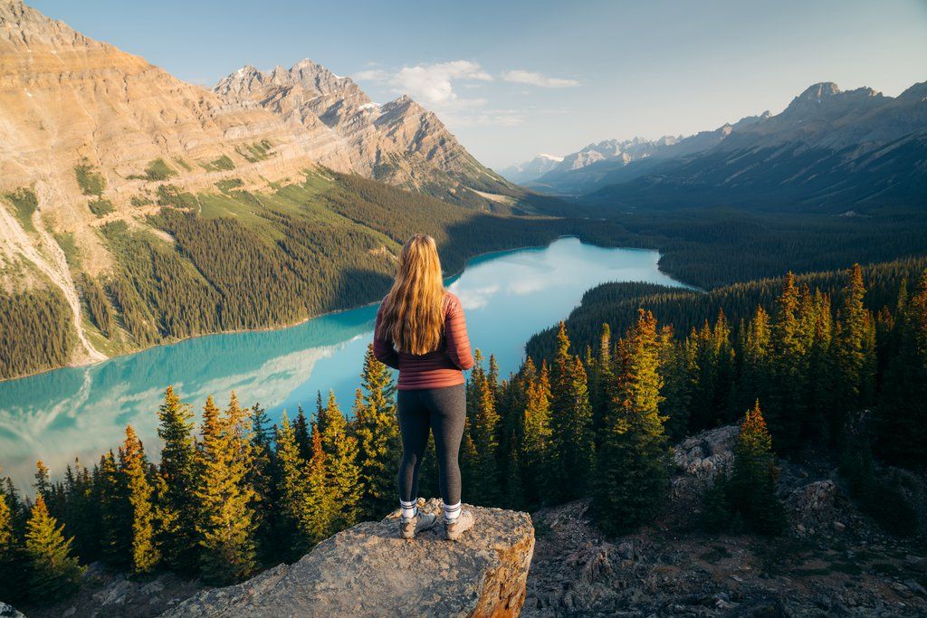 image Breathe in fresh mountain air as you stand with a stunning lake reflecting the peaks behind you.