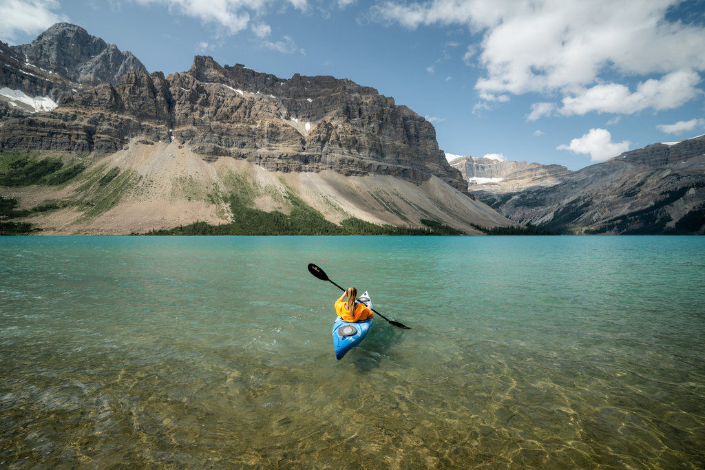 image Paddle through crystal clear waters with towering mountains guiding your journey.