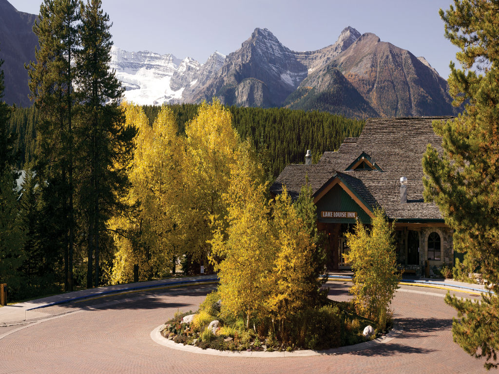 image Arrive at the charming entrance framed by vibrant autumn colors and majestic mountains.