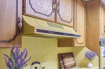 Kettle, burners, and small appliances on the kitchen counter under warm overhead lighting