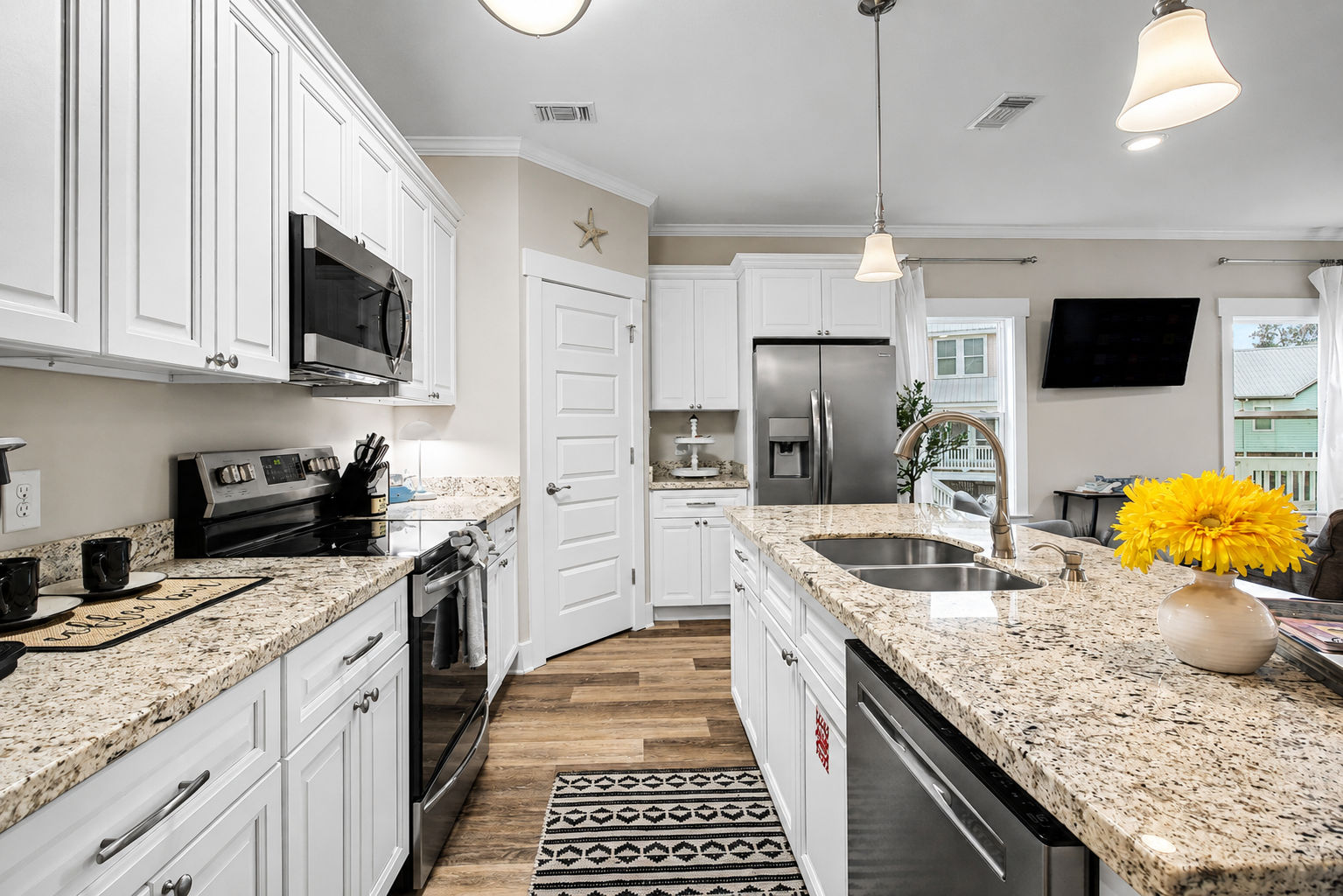 image Kitchen from a second angle, showing white upper cabinets and contemporary pendant lighting above the counter