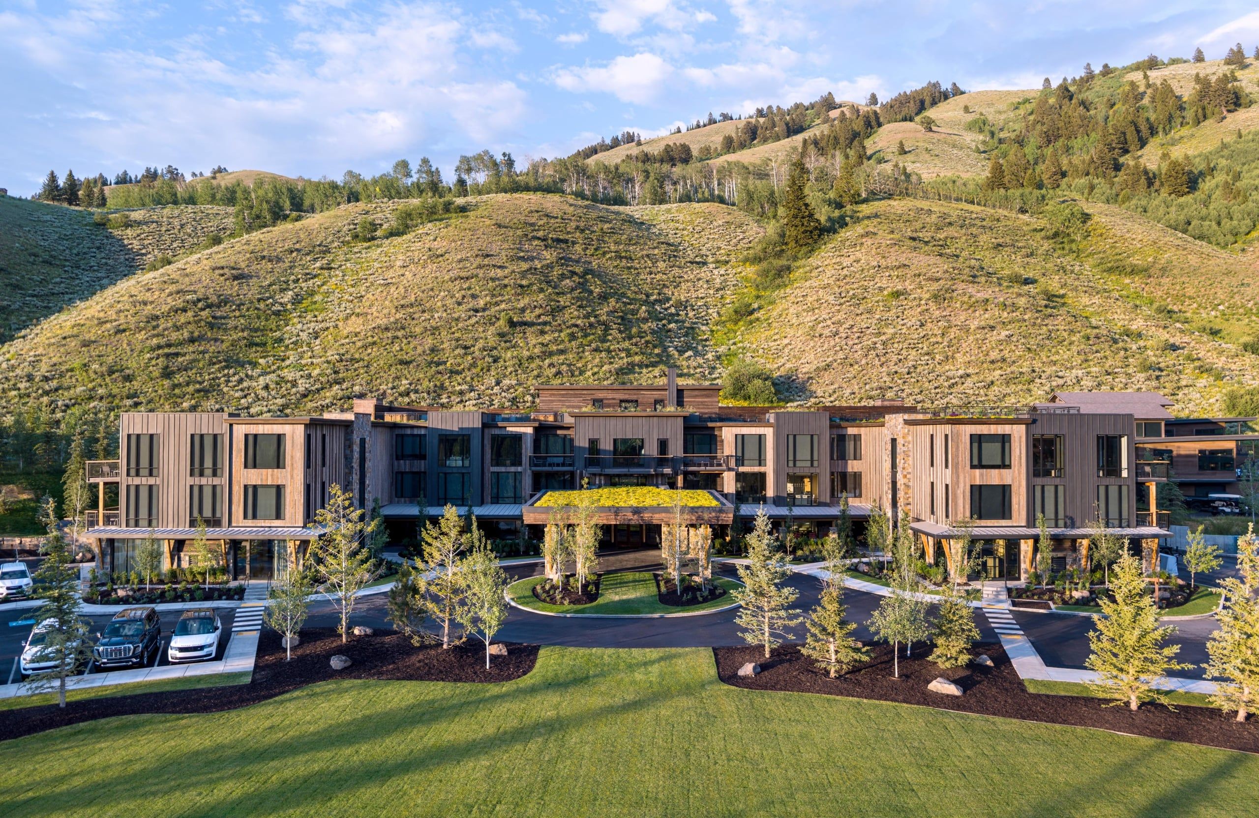 image Wood-and-stone lodge exterior framed by the Teton peaks — your gateway to 1,000 acres of private Wyoming wilderness