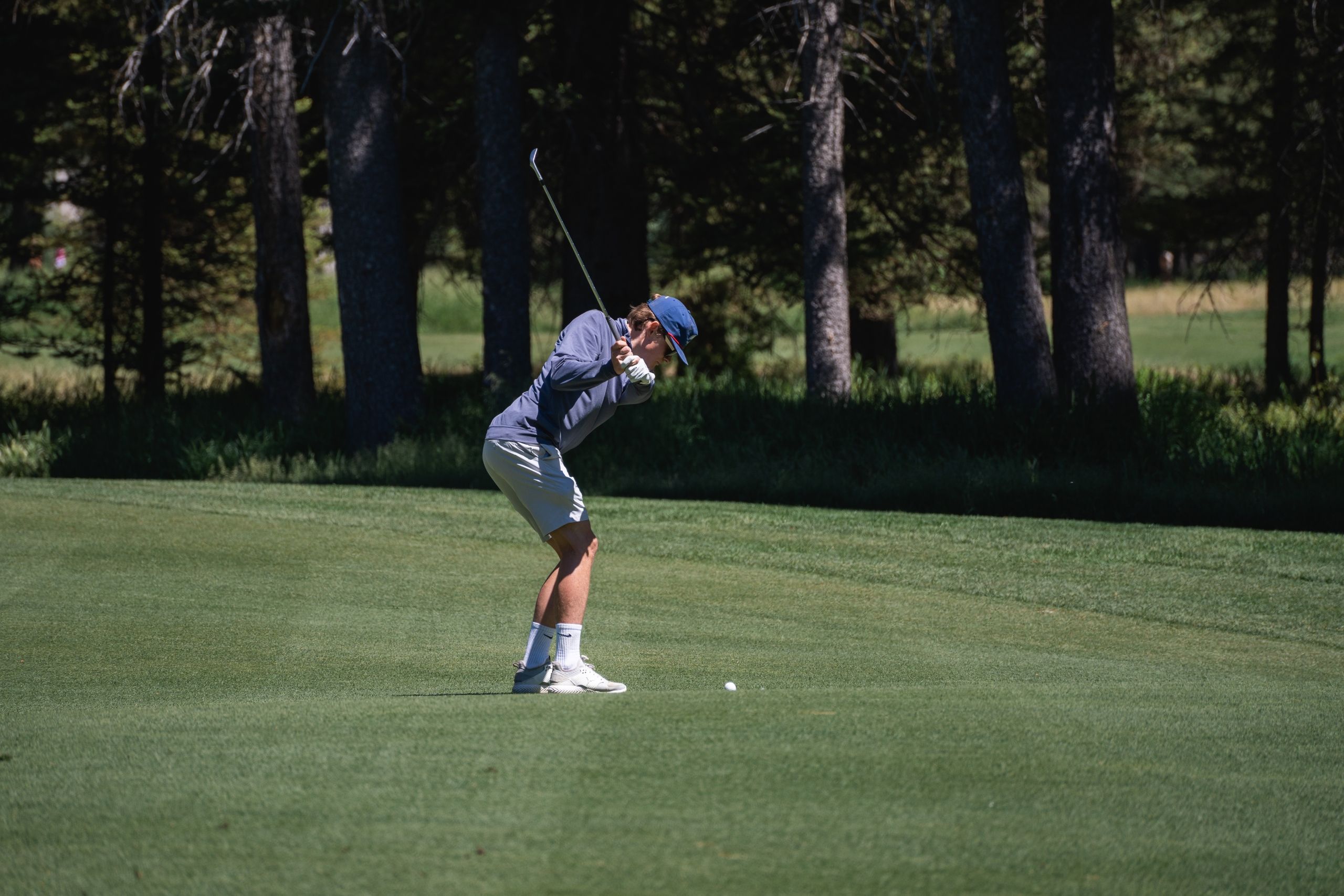 image Mid-swing on the Tom Weiskopf-designed 18-hole championship course, with mountain ridgelines in every sightline