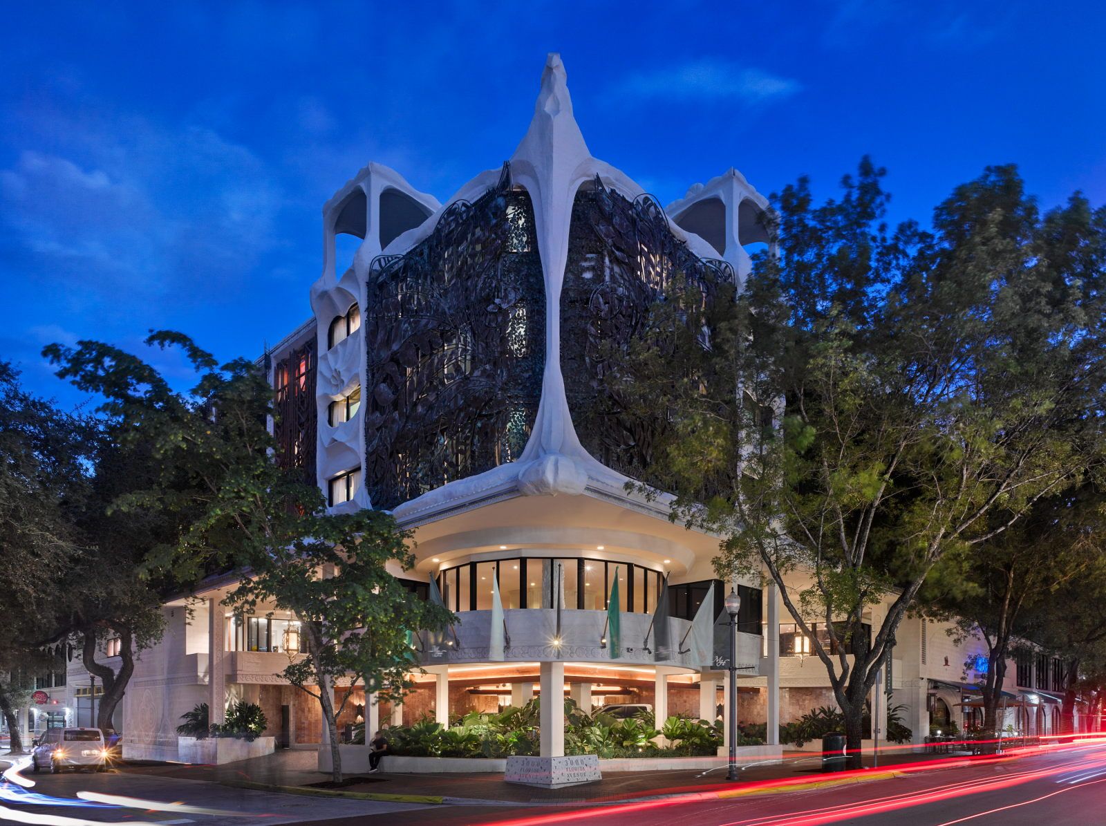 image A striking facade with organic shapes and intricate carved details merges with lush surroundings at twilight