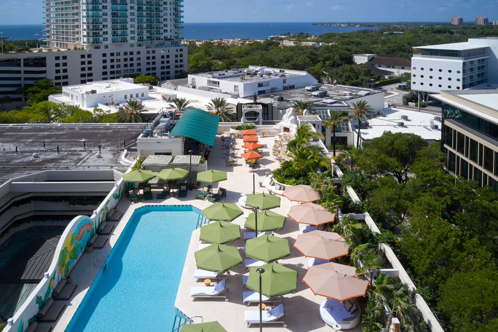 image Take in panoramic views while relaxing by the rooftop pool, accentuated by vibrant umbrellas and tropical trees