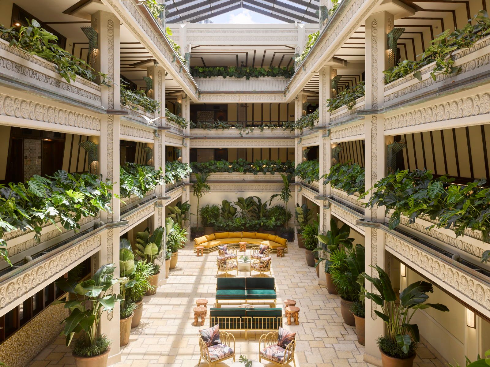 image Lush greenery fills the atrium, where intricately carved columns rise around plush seating areas