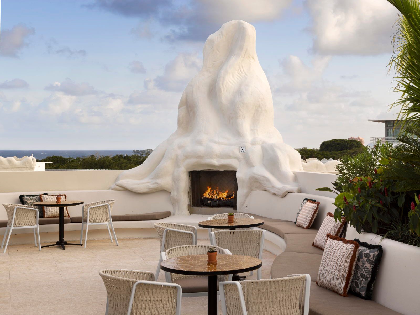 image Outdoor terrace with a fireplace, low seating, and an abstract sculptural feature in the foreground