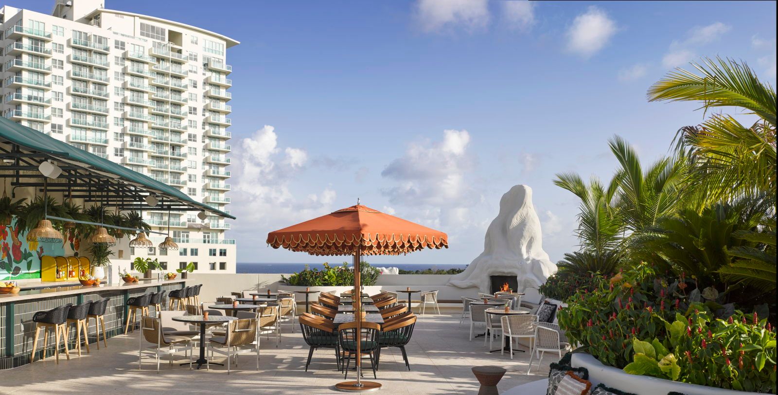 image Rooftop bar with vibrant decor, comfortable seating, and scenic ocean views stretching to the horizon
