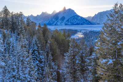 Forest and mountains catch the first light of a winter sunrise.