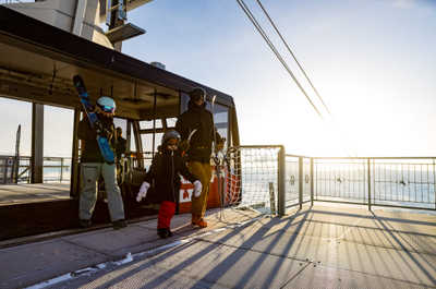 Skis in hand, one family steps off the tram at the summit.