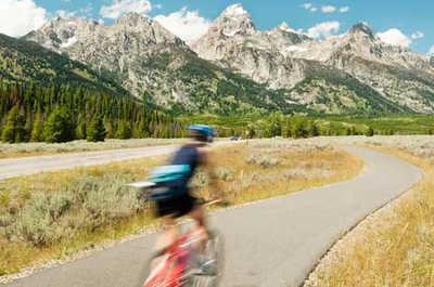 Cyclists ride past the Teton Mountains outside Jackson Hole, Wyoming.