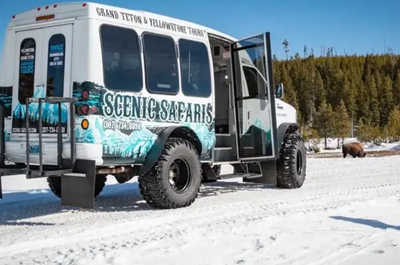 Wildlife safari vehicles pause in the snow while touring Grand Teton.