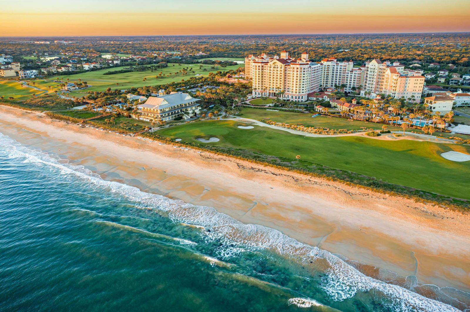 image Golden sands and rolling Atlantic waves at sunset, with the resort tower and golf greens behind