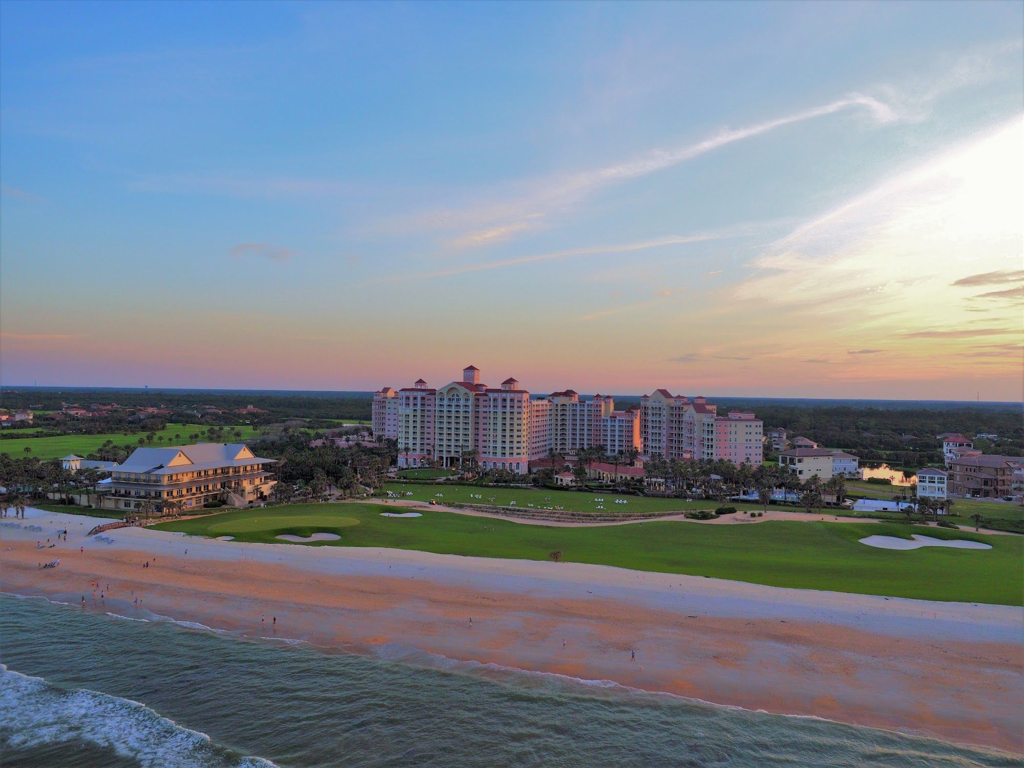 image Resort tower overlooking a wide sandy beach under a pastel evening sky