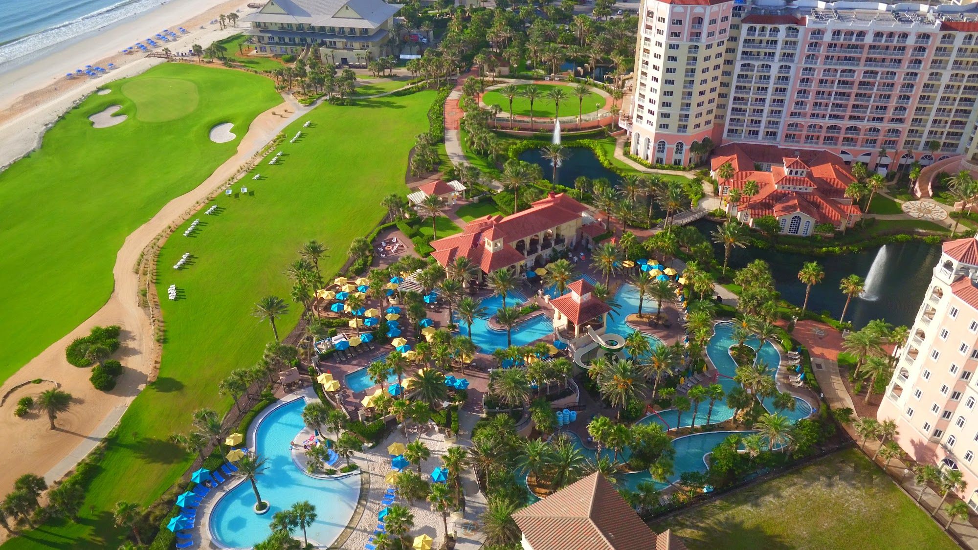 image Aerial view of the pool complex with colourful umbrellas and palm trees