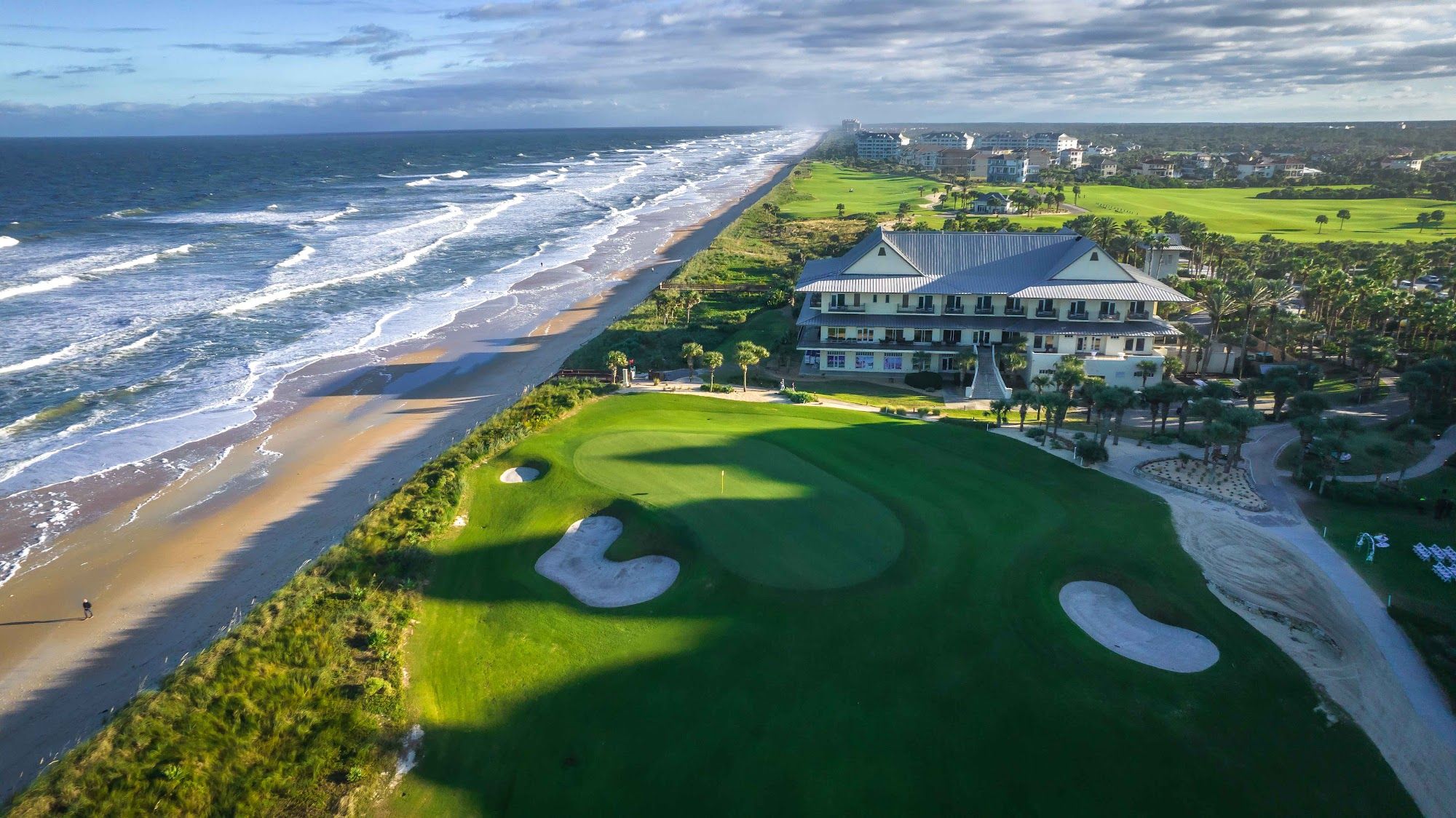 image Aerial view of the golf course meeting the sandy beach at the water's edge