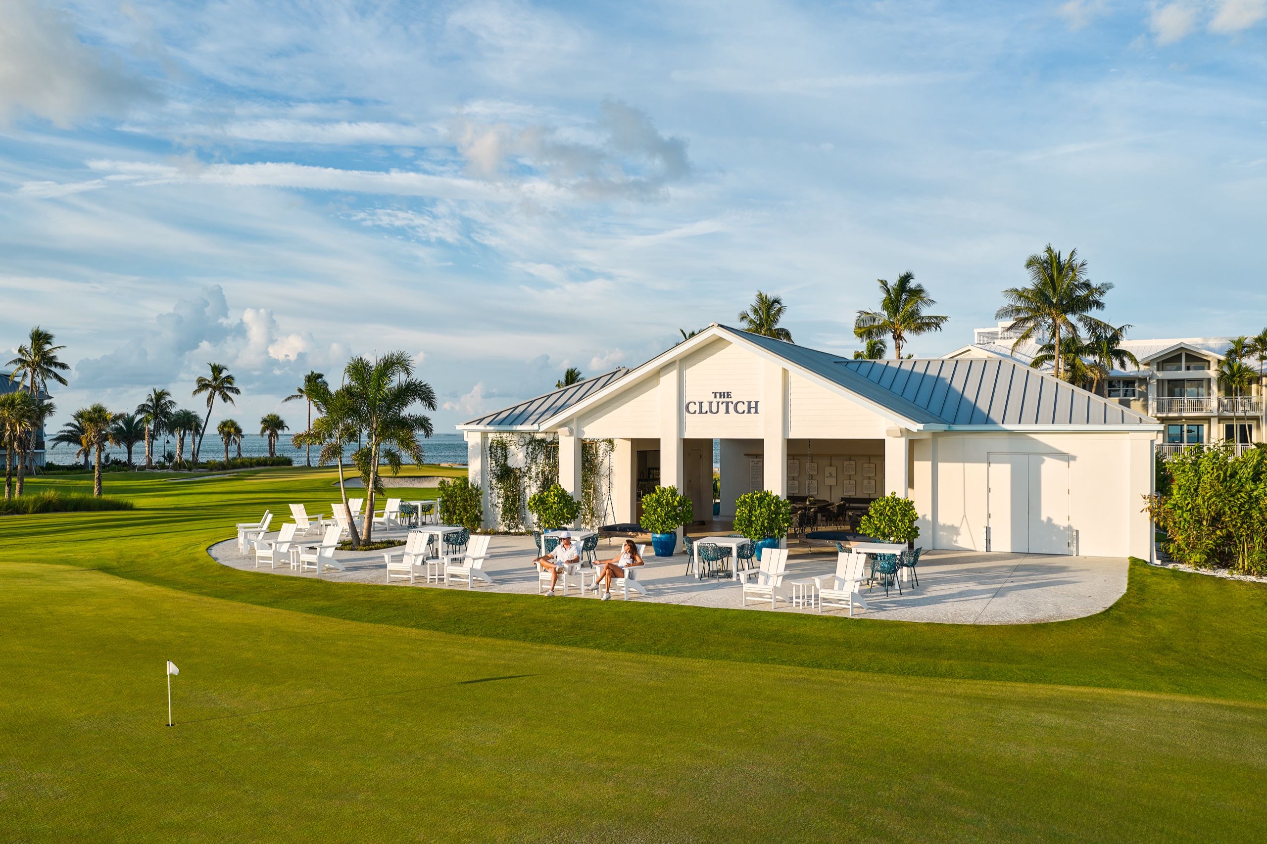 image Overlooking the greens, The Clutch Clubhouse sets the scene for relaxed, sunset-lit dining after a day on the course.