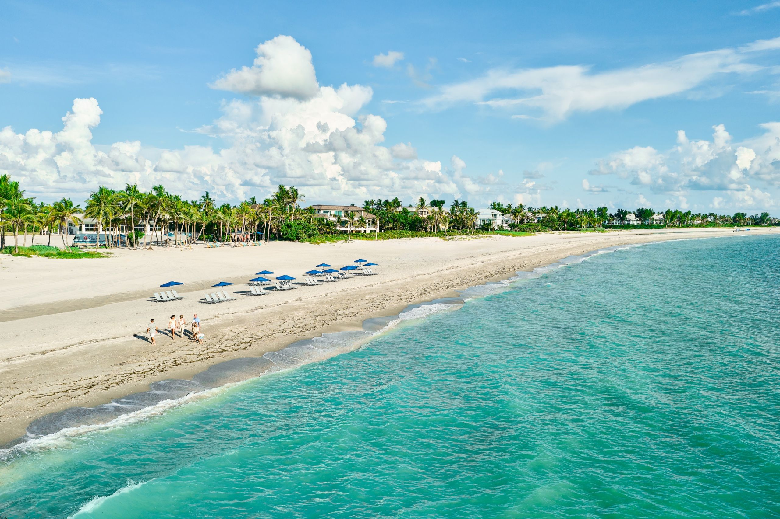 image Overhead, the Gulf beach stretches out, sand meeting turquoise shallows.