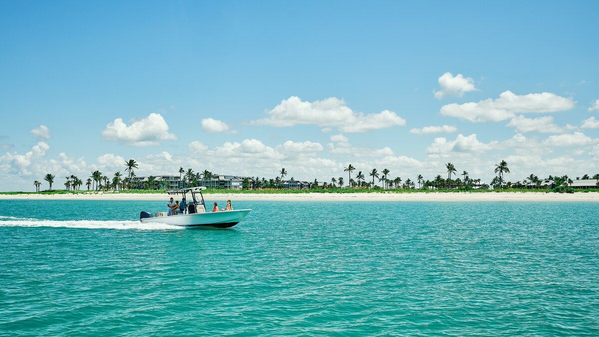 image Glide along the coastline aboard a boat, open water stretching toward the horizon.