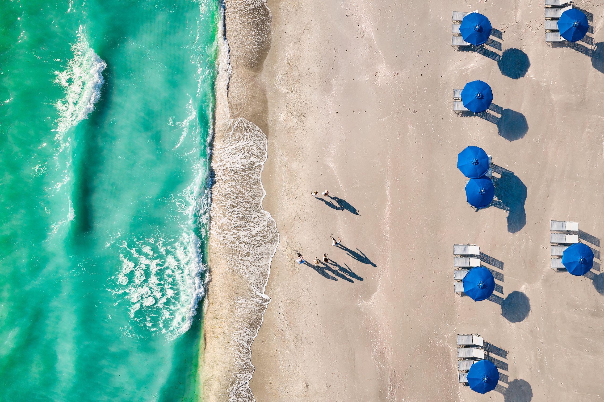 image From above, the beach meets the Gulf waters in bands of blue.