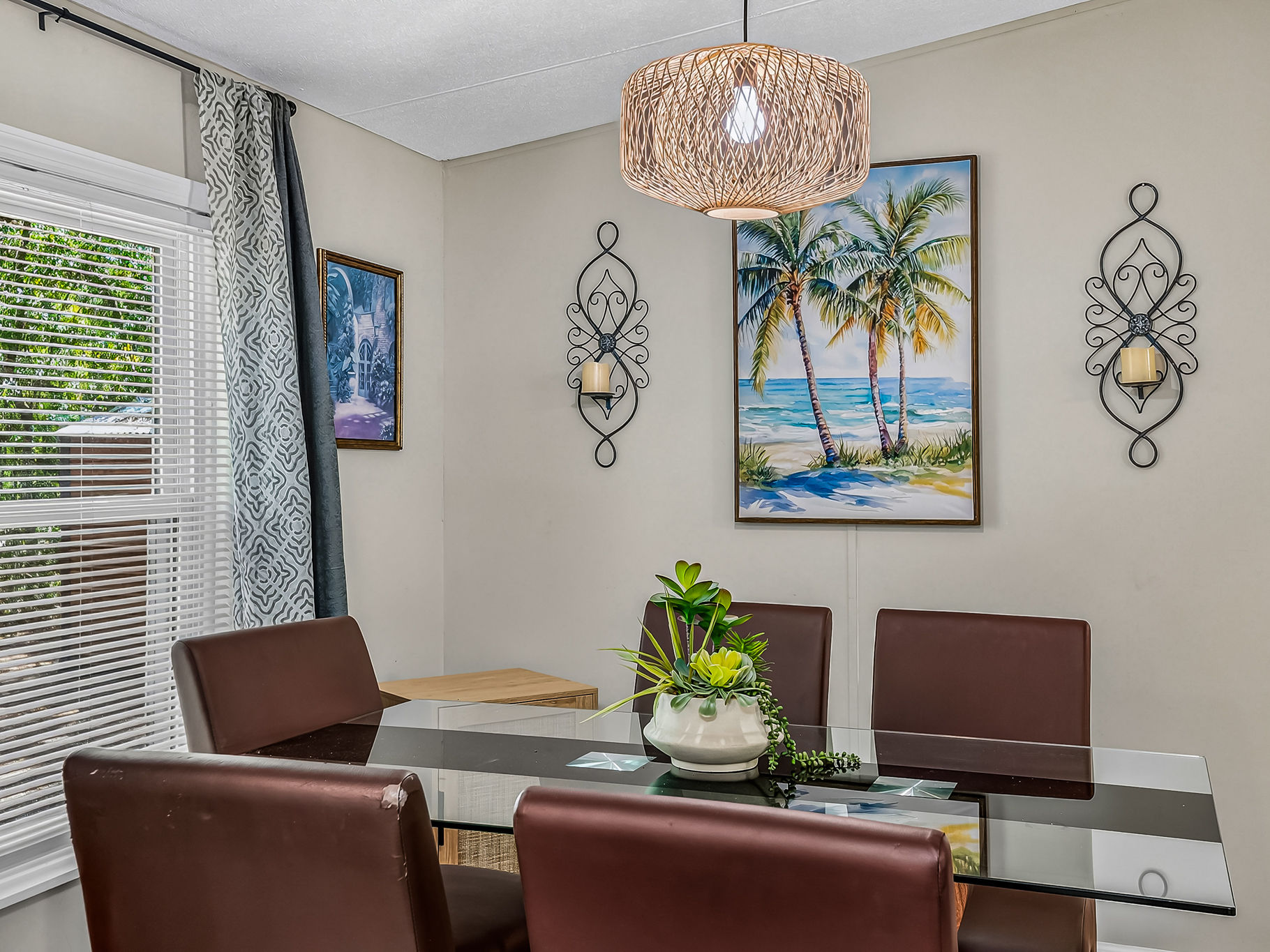 image Tropical wall art adds a splash of color above the dining table.