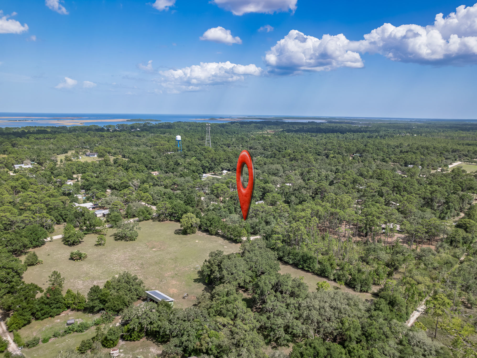 image Aerial view showing the property's location amid lush greenery, with the coastline in the distance.