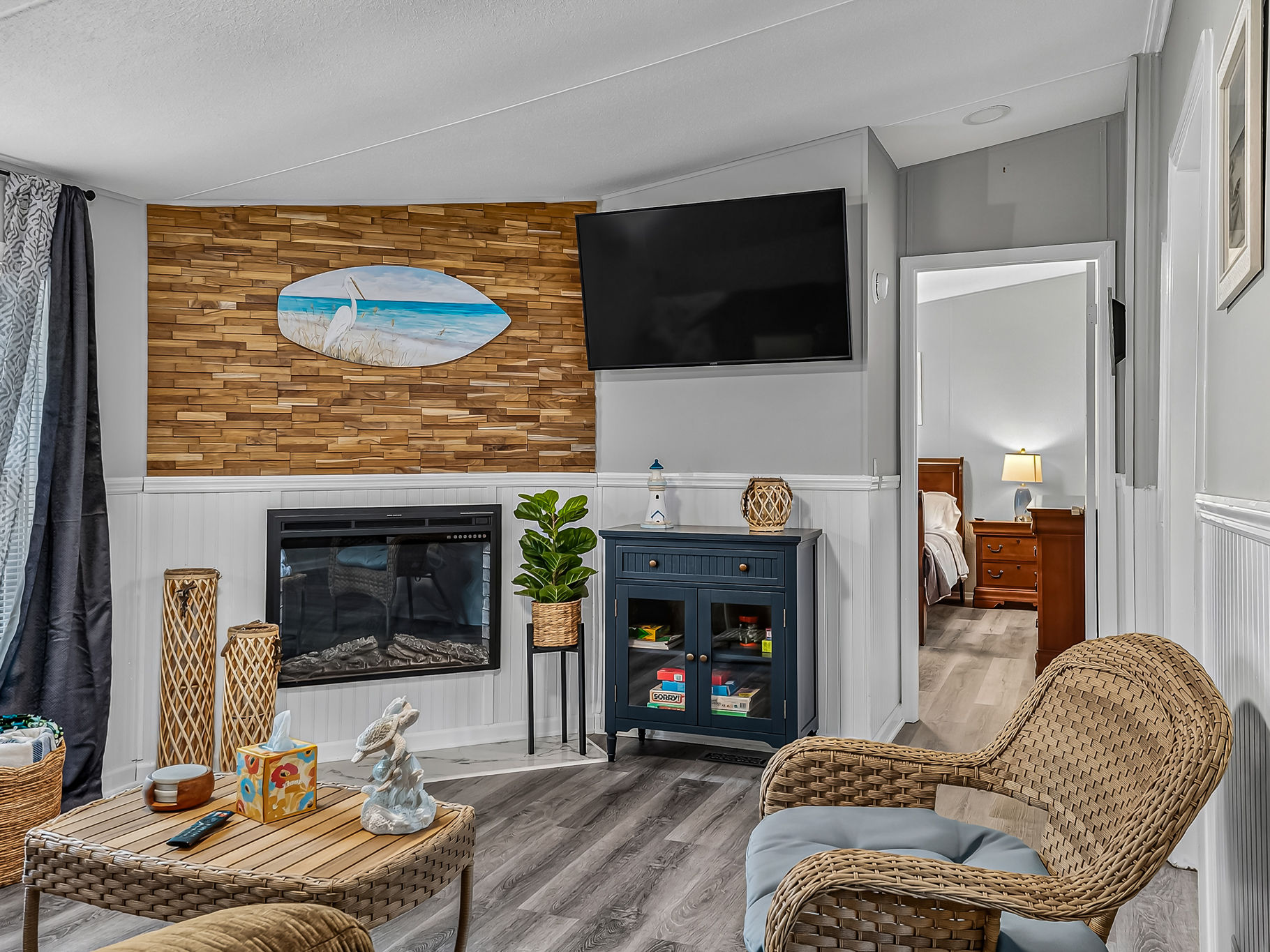 image Sectional couch and wall-mounted TV anchor the living room, with windows framing the yard.