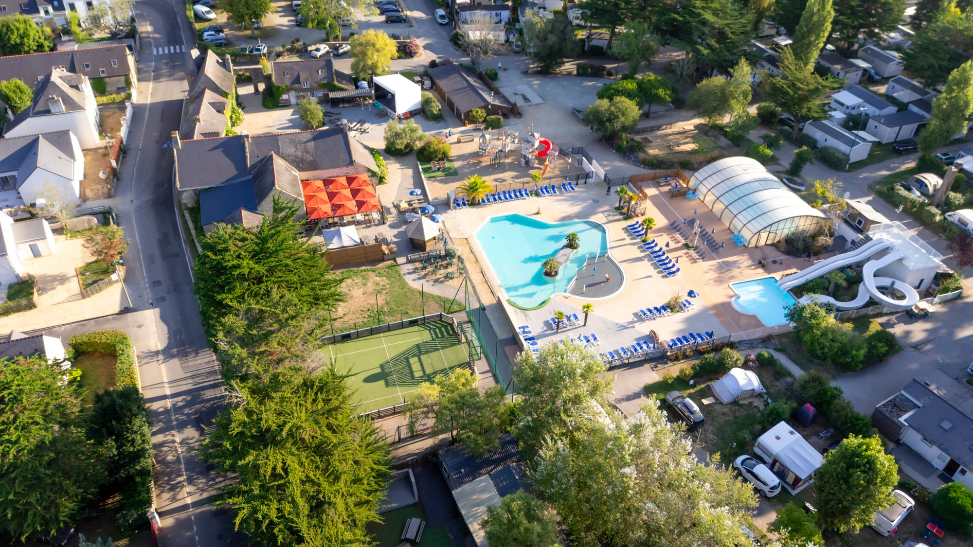 image Aerial view of the pool area alongside the multisports field and shaded lounging space.