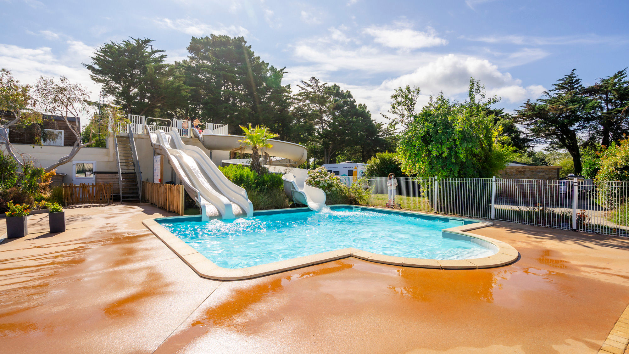 image The outdoor pool with its tall water slides, framed by lush greenery.