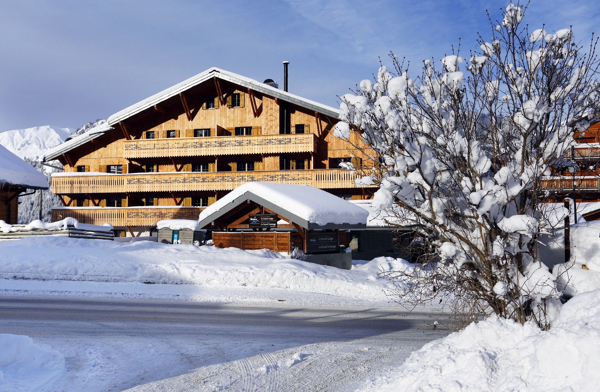 image Wooden building and snow-laden tree in snowy landscape