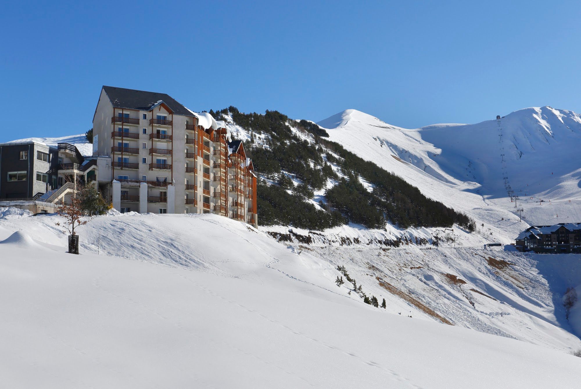 image Chalet-style residence in deep snow with the pistes rising behind