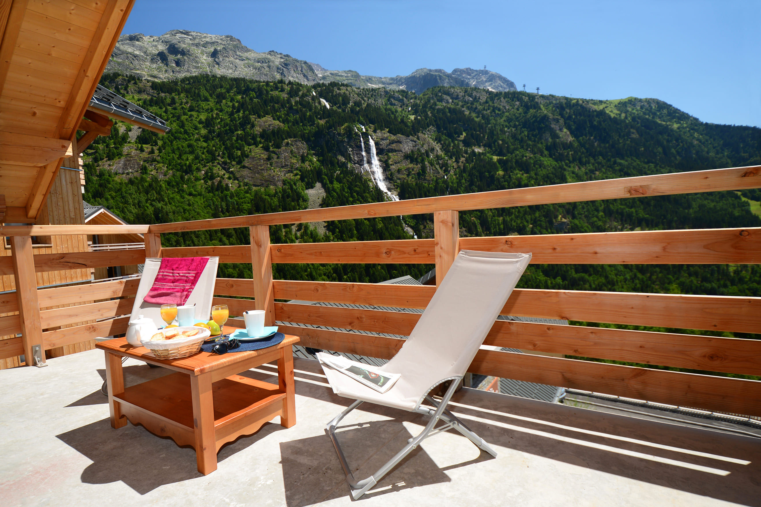 image Balcony breakfast table with a view of a waterfall in the mountains