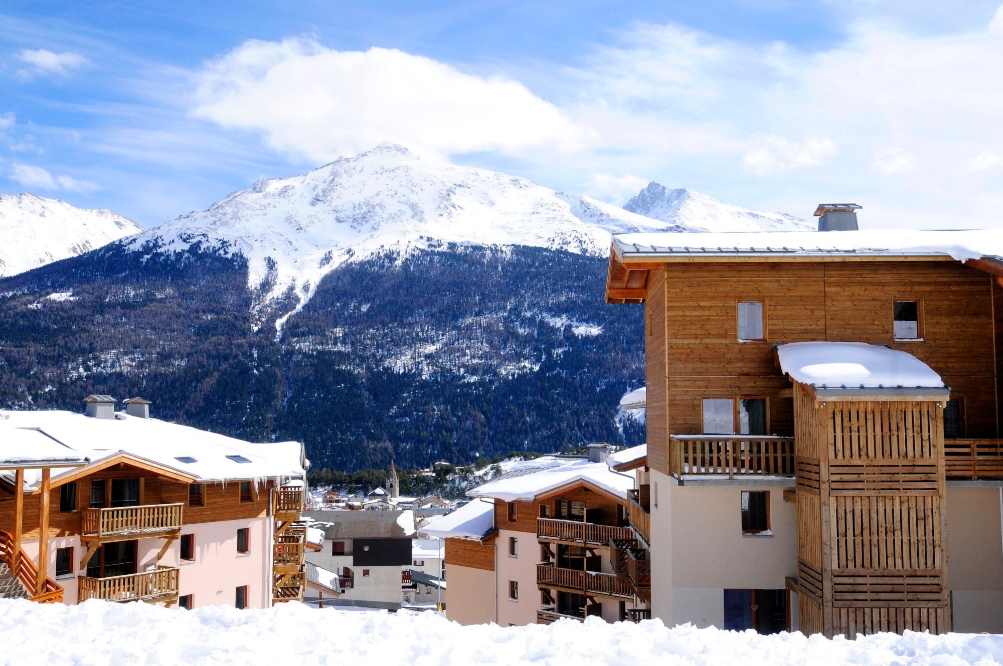 image Timber-balconied buildings with a broad mountain panorama behind