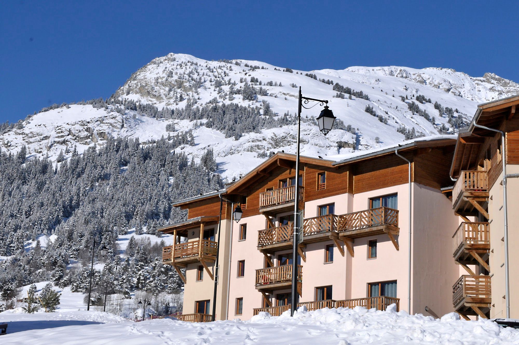 image Chalet-style apartment block with timber balconies in deep snow
