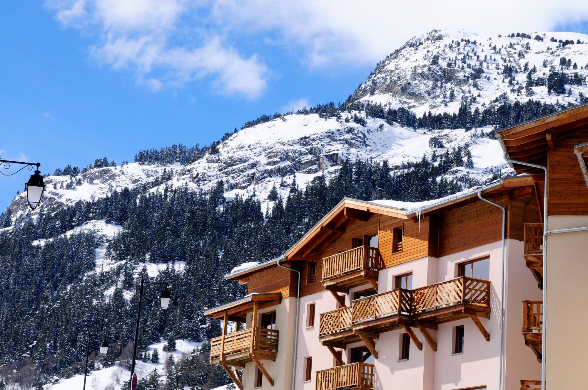 image Apartment building with timber balconies beneath a rocky snow-capped peak