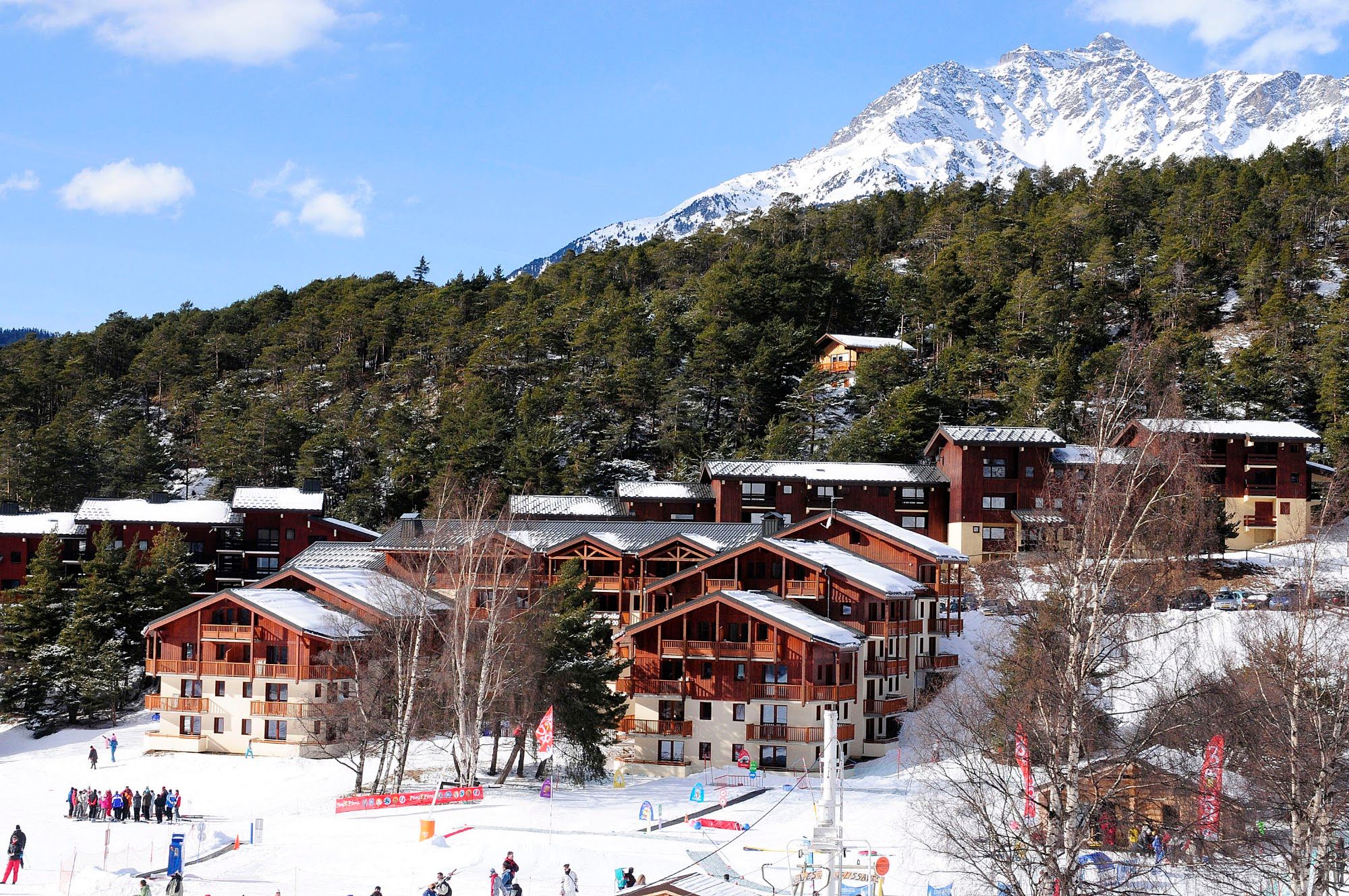 image Apartment buildings with ski pistes running to their foot, peaks behind