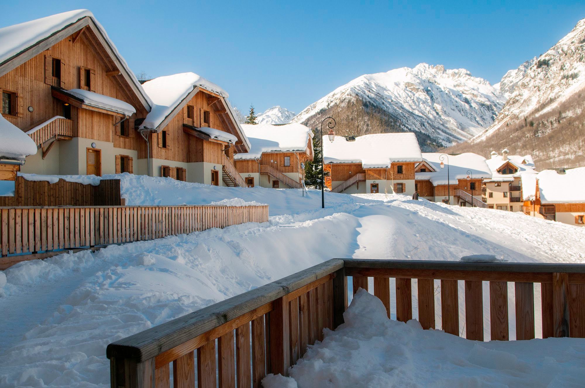 image Wooden chalets surrounded by snow with mountains in the background