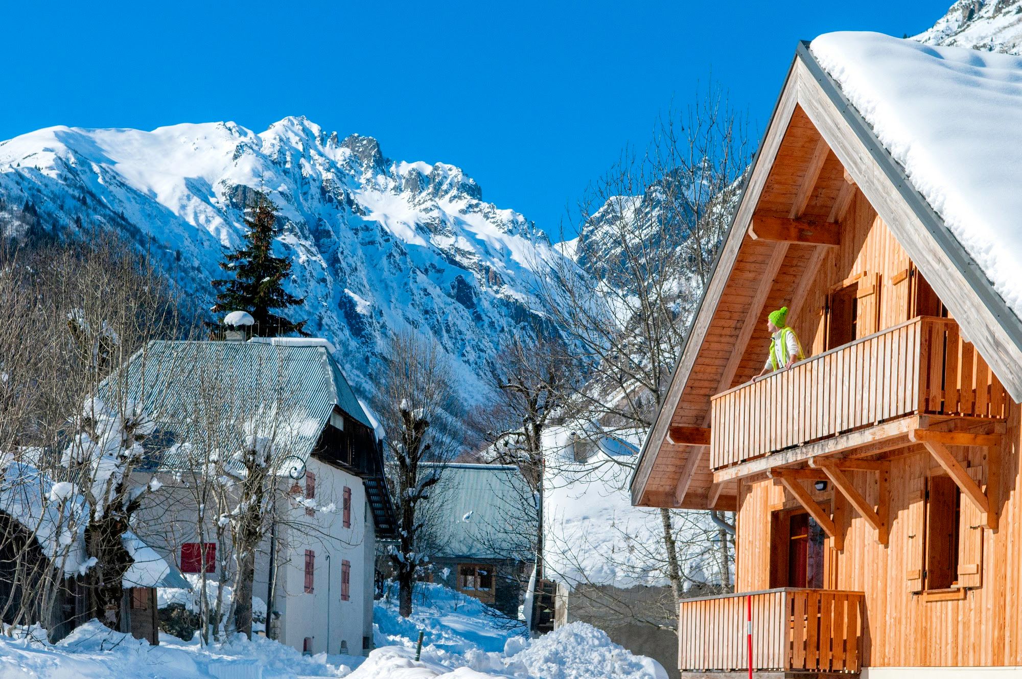 image Balcony view of wooden chalets with snow-capped mountains nearby