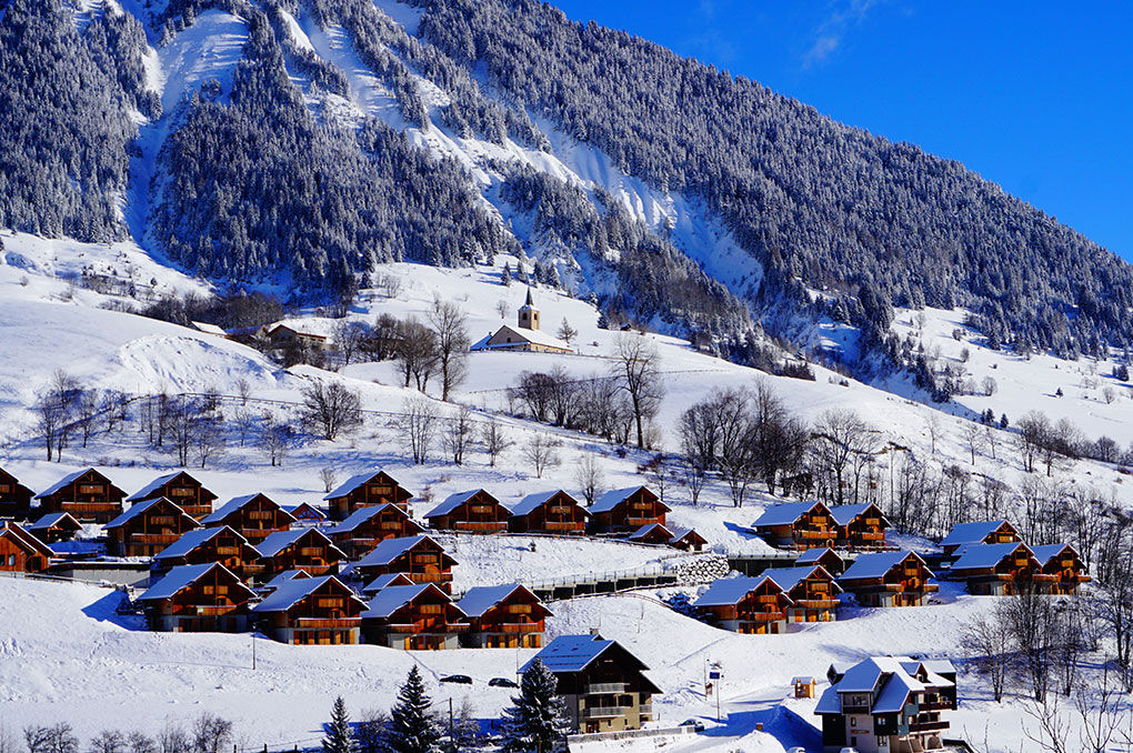 image Wide aerial village/chalet cluster view, winter, mountain backdrop